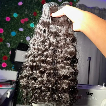 Raw Virgin Human Hair Bundles held in hand, showcasing natural waves and luxurious texture.